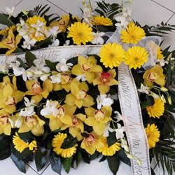 Cuscino con base di orchidee e altri fiori in base alla stagionalità € 90,00 <br/><a class='link-form' href='form_info-fiori.php?ID_prod=Cuscino base orchidee gialle&source=invio-fiori-per-funerale'>ORDINA ORA!